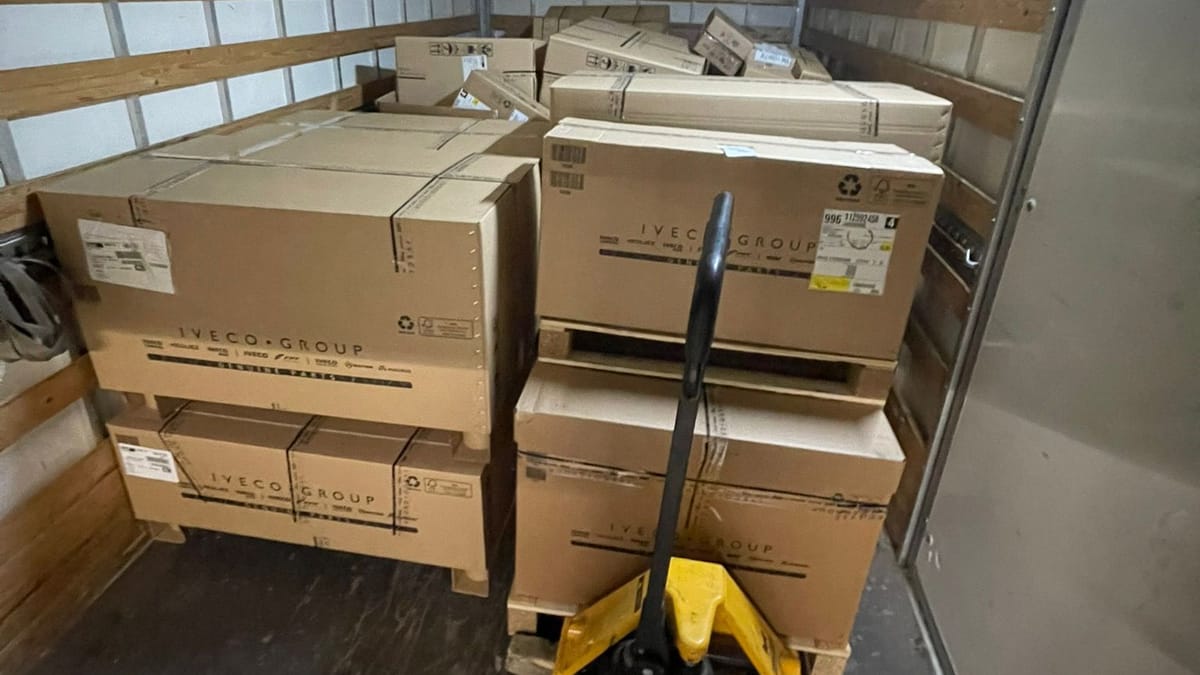 Gestapelde dozen op pallets met een palletwagen in de laadruimte