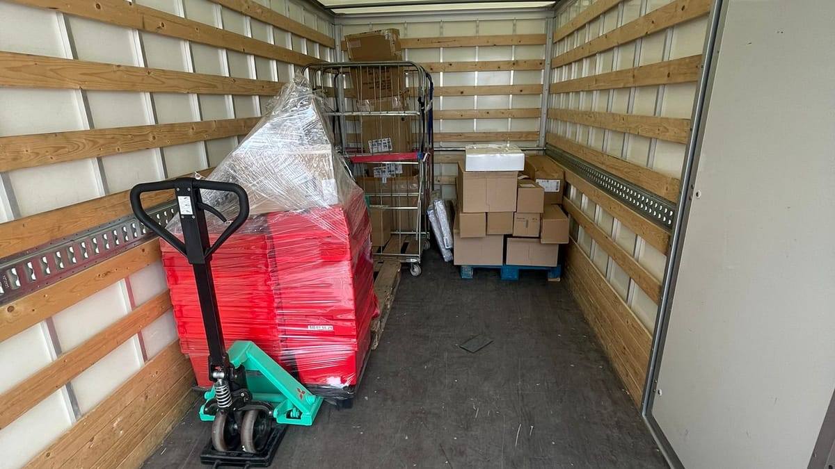 Kratten, dozen en een rolcontainer in de laadruimte van een vrachtwagen